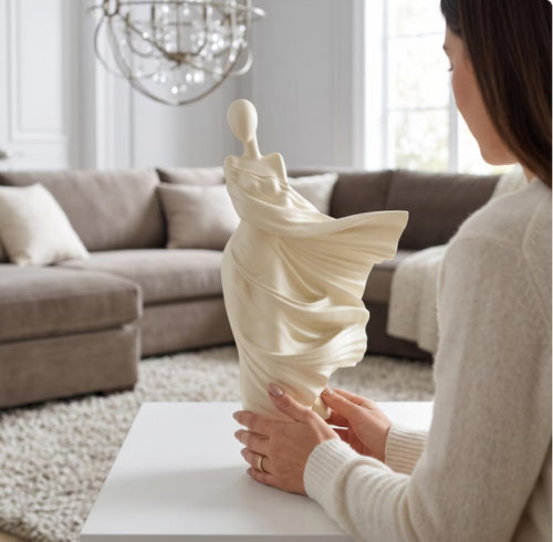 Woman placing ivory abstract figure sculpture on white console table in luxury living room | ULAD CO handmade resin art South Africa